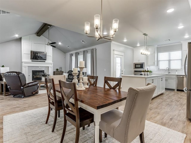 1391 Hickory Trl, Piedmont, OK 73078 - dining space with a glass covered fireplace, light wood-style floors, recessed lighting, a chandelier, and crown molding