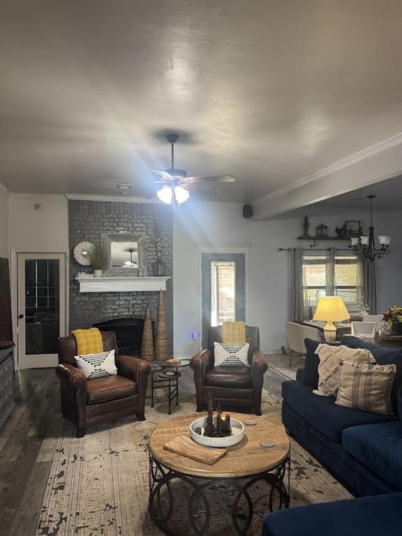 7013 Morning Song Dr, Oklahoma City, OK 73150 - living area with wood finished floors, a fireplace, ceiling fan, crown molding, and a chandelier