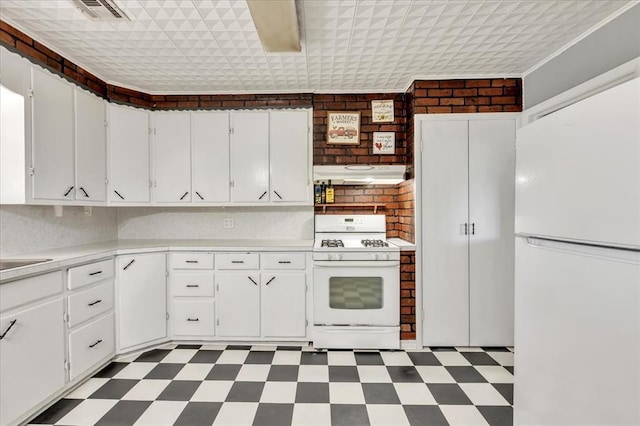 601 N Dobbs Rd, Harrah, OK 73045 - kitchen with white appliances, under cabinet range hood, tile patterned floors, and light countertops