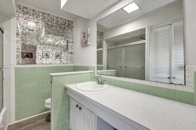 601 N Dobbs Rd, Harrah, OK 73045 - bathroom with vanity, tile walls, wood finished floors, and wainscoting