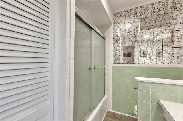 601 N Dobbs Rd, Harrah, OK 73045 - bathroom with tile walls, wood finished floors, enclosed tub / shower combo, and vanity