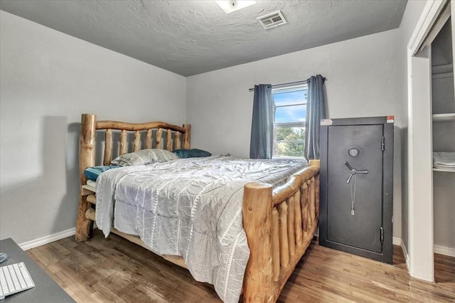 601 N Dobbs Rd, Harrah, OK 73045 - bedroom with wood finished floors and a textured ceiling