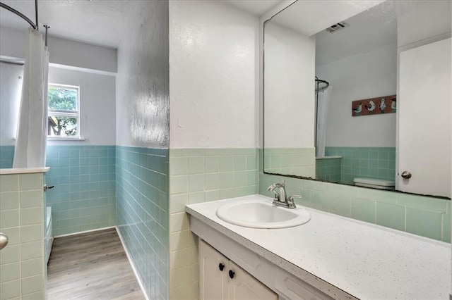 601 N Dobbs Rd, Harrah, OK 73045 - full bathroom featuring tile walls, vanity, wood finished floors, wainscoting, and a textured wall