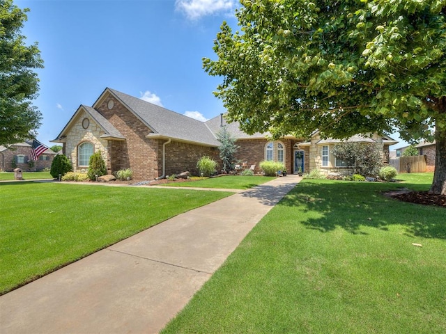 2009 Pembroke Ln, Edmond, OK 73003 - view of front facade with stone siding, roof with shingles, and brick siding