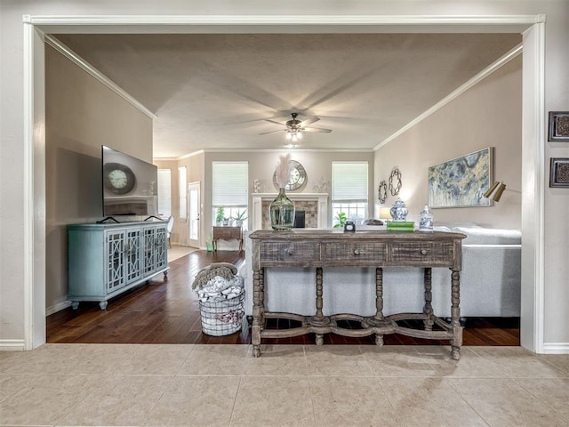 2009 Pembroke Ln, Edmond, OK 73003 - tiled living area with crown molding, ceiling fan, plenty of natural light, and a fireplace