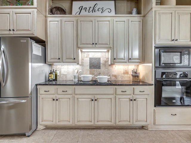 2009 Pembroke Ln, Edmond, OK 73003 - kitchen featuring black appliances, cream cabinetry, dark stone countertops, and tasteful backsplash