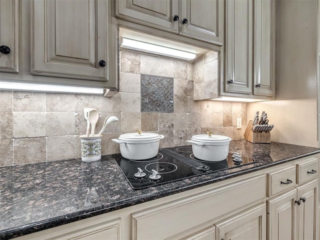 2009 Pembroke Ln, Edmond, OK 73003 - kitchen with decorative backsplash, black electric stovetop, and dark stone countertops