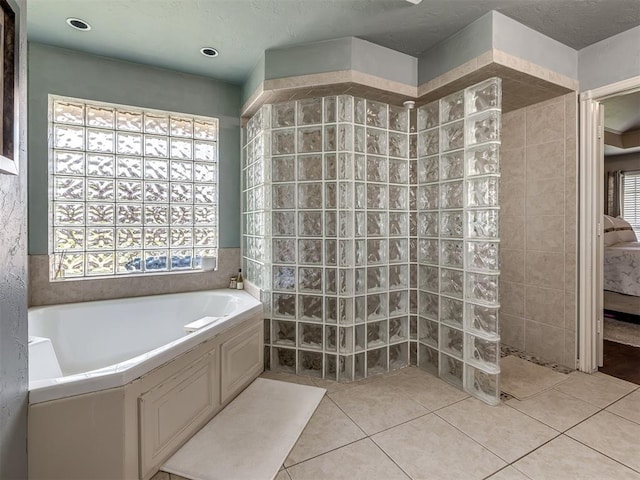 2009 Pembroke Ln, Edmond, OK 73003 - bathroom featuring a garden tub, a walk in shower, tile patterned flooring, and ensuite bath