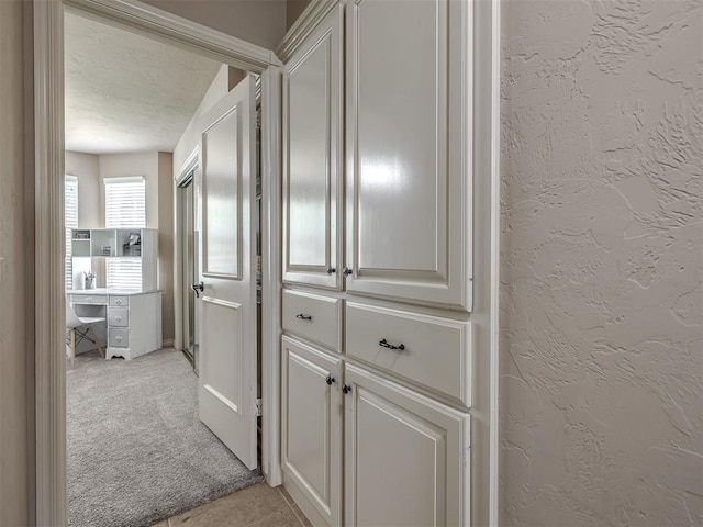 2009 Pembroke Ln, Edmond, OK 73003 - corridor with light colored carpet, a textured ceiling, and a textured wall