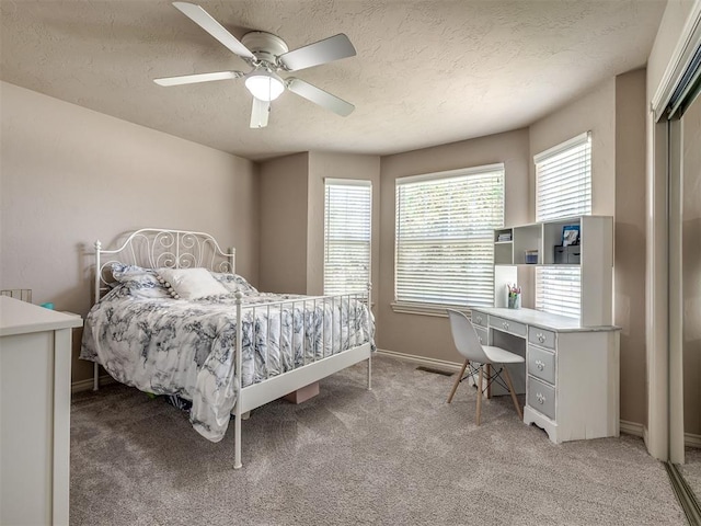 2009 Pembroke Ln, Edmond, OK 73003 - bedroom with light carpet, a textured ceiling, ceiling fan, and a desk