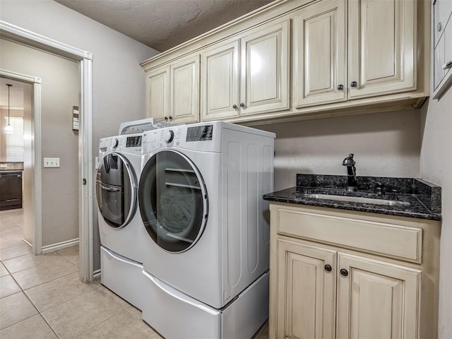2009 Pembroke Ln, Edmond, OK 73003 - laundry area featuring washer and clothes dryer, cabinet space, and light tile patterned floors