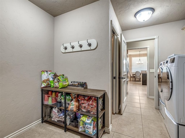 2009 Pembroke Ln, Edmond, OK 73003 - laundry area with washer and dryer, a textured ceiling, light tile patterned floors, a textured wall, and a chandelier