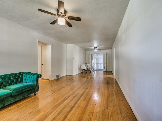 3804 NW 52nd St, Oklahoma City, OK 73112 - living room featuring a ceiling fan, light wood finished floors, and a textured ceiling