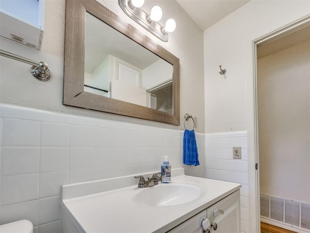 3804 NW 52nd St, Oklahoma City, OK 73112 - bathroom with tile walls, vanity, and a wainscoted wall