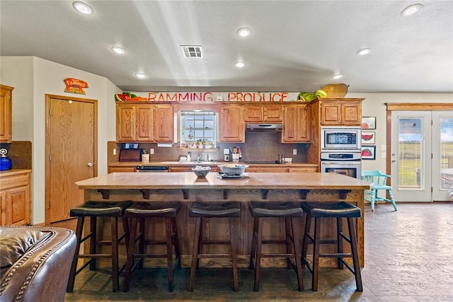 5097 County St Unit 2580, Hinton, OK 73047 - kitchen featuring stainless steel appliances, recessed lighting, a kitchen island, decorative backsplash, and a breakfast bar