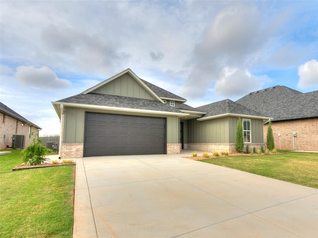 216 Pont Neuf Ct, Edmond, OK 73034 - view of front of home with brick siding, board and batten siding, a garage, a front lawn, and driveway