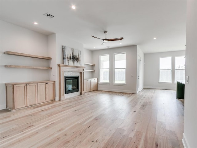 216 Pont Neuf Ct, Edmond, OK 73034 - unfurnished living room featuring a fireplace, healthy amount of natural light, ceiling fan, light wood-style flooring, and recessed lighting
