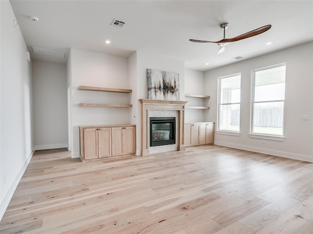 216 Pont Neuf Ct, Edmond, OK 73034 - unfurnished living room featuring light wood-type flooring, ceiling fan, a high end fireplace, and recessed lighting
