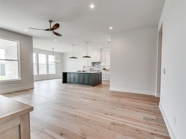 216 Pont Neuf Ct, Edmond, OK 73034 - unfurnished living room with a ceiling fan, a chandelier, light wood finished floors, and recessed lighting