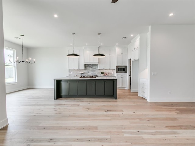 216 Pont Neuf Ct, Edmond, OK 73034 - kitchen featuring white cabinetry, stainless steel microwave, backsplash, light wood-style floors, and recessed lighting