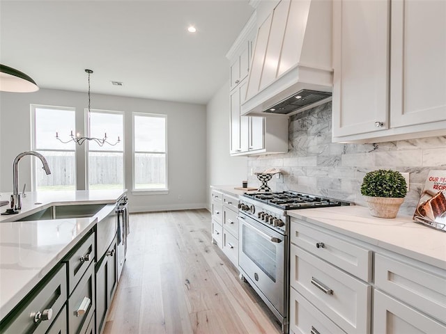 216 Pont Neuf Ct, Edmond, OK 73034 - kitchen featuring custom range hood, high end range, light stone counters, decorative backsplash, and white cabinetry