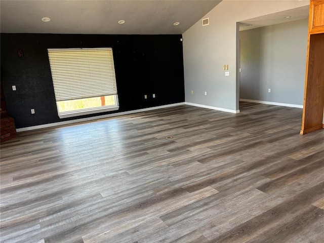 spare room with wood finished floors, vaulted ceiling, and recessed lighting