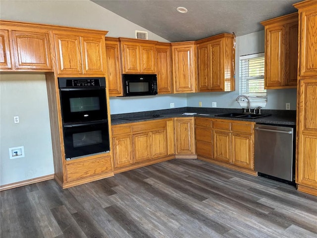 kitchen with black appliances, lofted ceiling, dark wood finished floors, dark countertops, and brown cabinetry