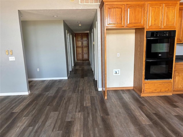kitchen featuring dark wood finished floors and brown cabinetry