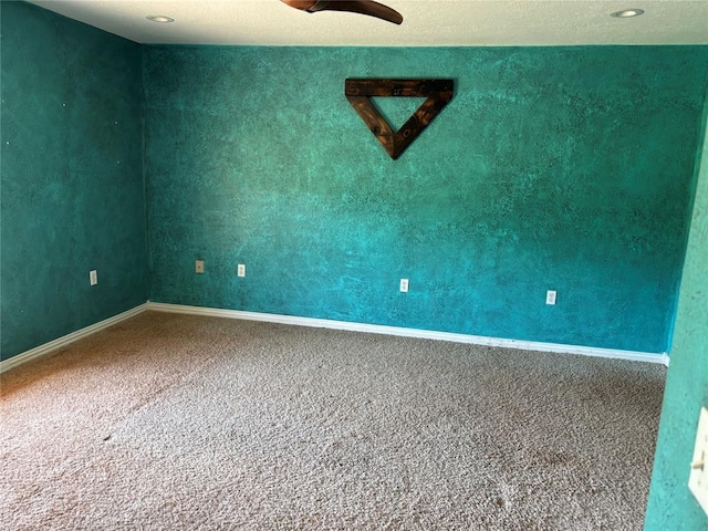 unfurnished room featuring carpet floors and baseboards