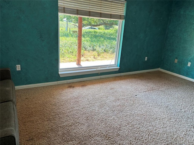 carpeted spare room featuring baseboards