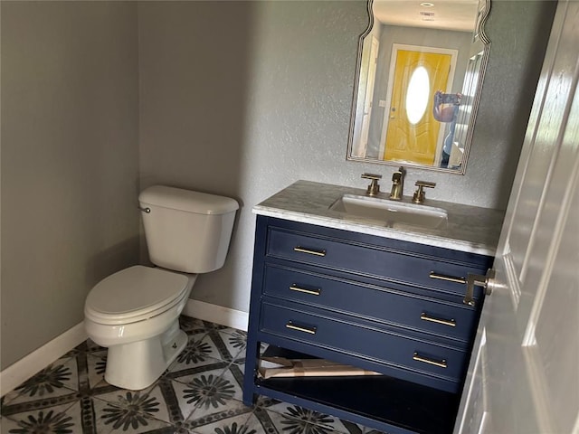 half bathroom featuring vanity, a textured wall, and tile patterned floors