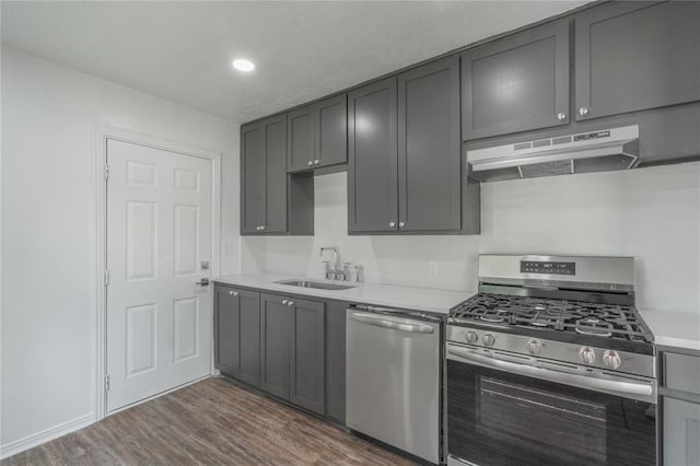 1120 SW 47th St, Oklahoma City, OK 73109 - kitchen featuring appliances with stainless steel finishes, under cabinet range hood, dark wood-type flooring, light countertops, and gray cabinets