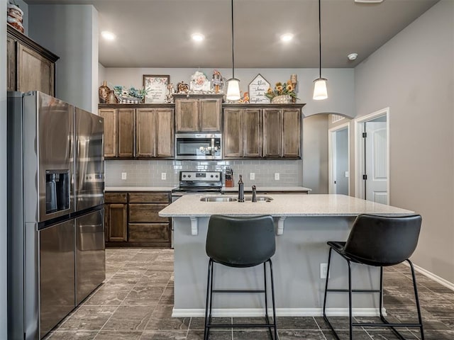 12812 Double V Dr, Piedmont, OK 73078 - kitchen featuring appliances with stainless steel finishes, arched walkways, backsplash, light stone countertops, and recessed lighting