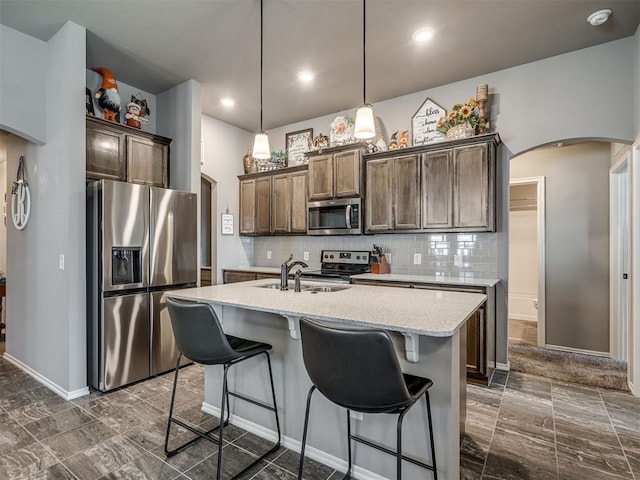 12812 Double V Dr, Piedmont, OK 73078 - kitchen featuring stainless steel appliances, arched walkways, tasteful backsplash, a kitchen island with sink, and recessed lighting