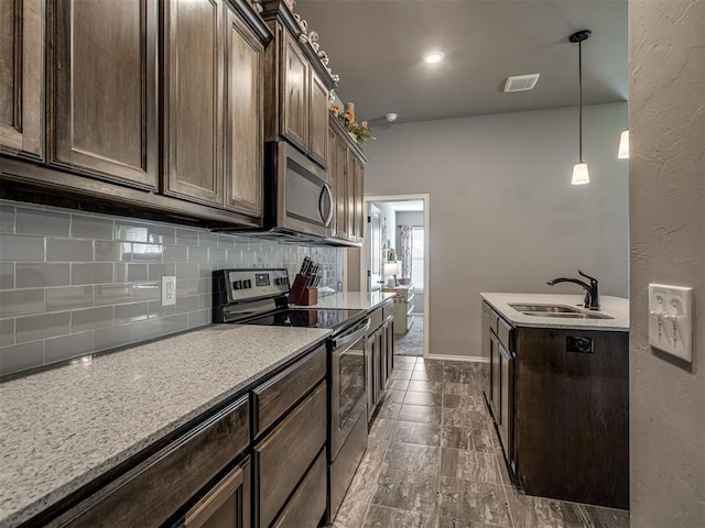 12812 Double V Dr, Piedmont, OK 73078 - kitchen featuring appliances with stainless steel finishes, decorative backsplash, dark brown cabinets, pendant lighting, and light countertops