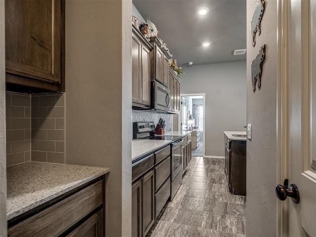 12812 Double V Dr, Piedmont, OK 73078 - kitchen featuring appliances with stainless steel finishes, decorative backsplash, dark brown cabinetry, and recessed lighting