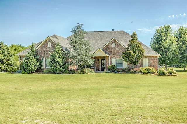 775 Magnolia Ln, Tuttle, OK 73089 - view of front of property with a front yard, brick siding, and roof with shingles