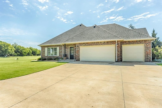 775 Magnolia Ln, Tuttle, OK 73089 - view of front facade with driveway, a front yard, an attached garage, brick siding, and roof with shingles