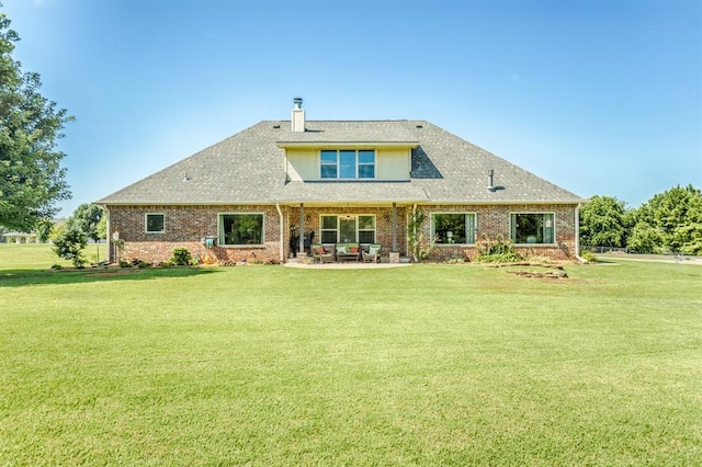 775 Magnolia Ln, Tuttle, OK 73089 - back of house with brick siding, a lawn, a chimney, and a patio area