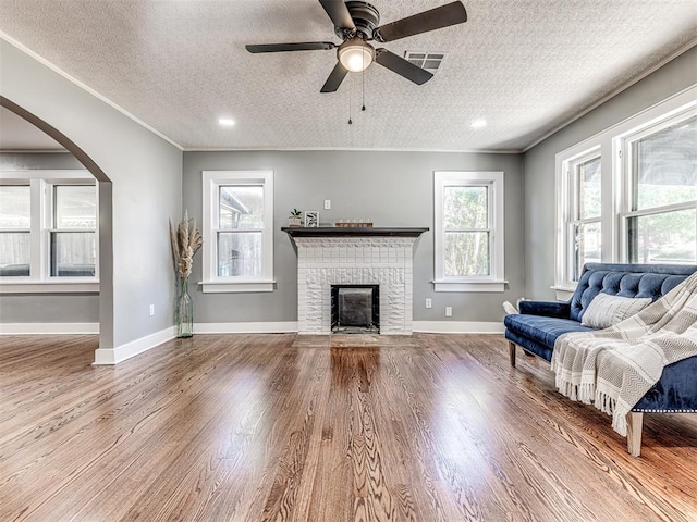 1623 NW 39th St, Oklahoma City, OK 73118 - living area with plenty of natural light, wood finished floors, arched walkways, a textured ceiling, and crown molding