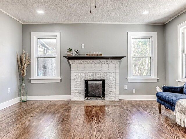 1623 NW 39th St, Oklahoma City, OK 73118 - living area featuring crown molding, a brick fireplace, wood finished floors, a textured ceiling, and recessed lighting