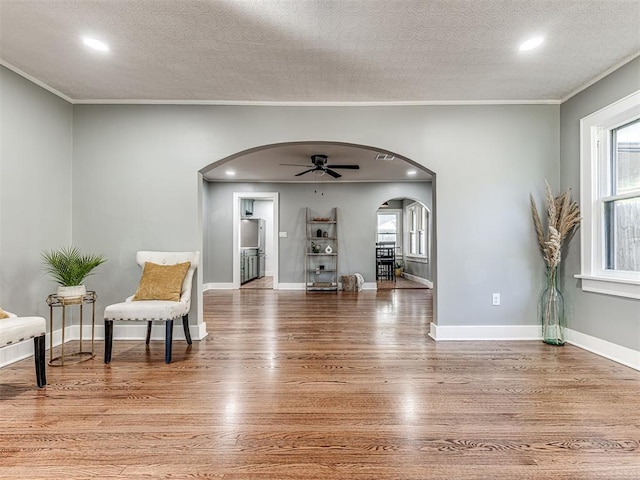 1623 NW 39th St, Oklahoma City, OK 73118 - living area with arched walkways, wood finished floors, ceiling fan, a textured ceiling, and crown molding