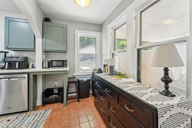1623 NW 39th St, Oklahoma City, OK 73118 - kitchen featuring stainless steel dishwasher, black microwave, light countertops, and light tile patterned floors