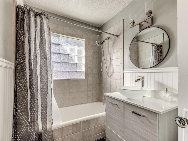1623 NW 39th St, Oklahoma City, OK 73118 - full bath with tiled shower / bath combo, vanity, a textured ceiling, wainscoting, and a decorative wall