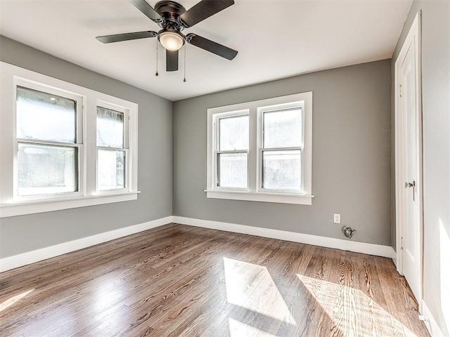 1623 NW 39th St, Oklahoma City, OK 73118 - empty room with healthy amount of natural light, wood finished floors, and a ceiling fan