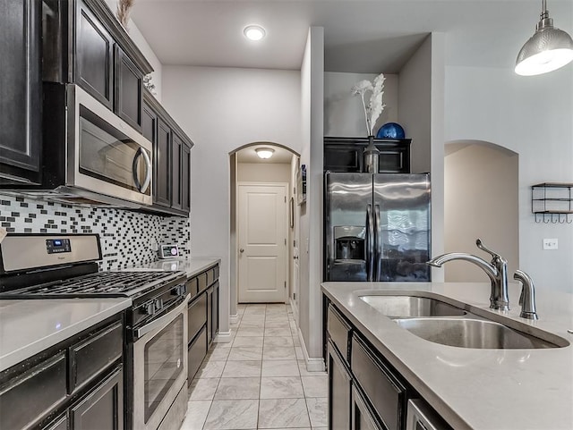 3529 Slate River Dr, Yukon, OK 73099 - kitchen with appliances with stainless steel finishes, arched walkways, light marble finish flooring, and dark cabinets