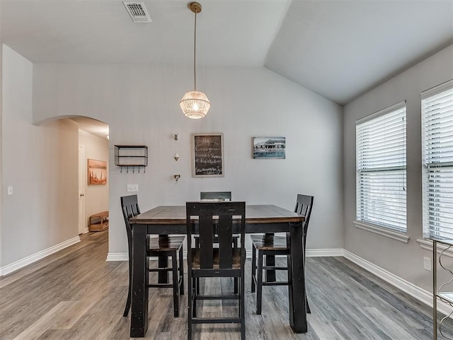 3529 Slate River Dr, Yukon, OK 73099 - dining area with arched walkways, wood finished floors, and vaulted ceiling
