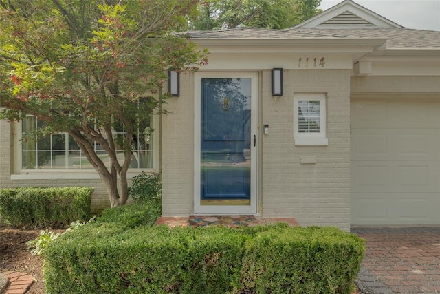 1114 Glenwood Ave, Nichols Hills, OK 73116 - property entrance with brick siding, an attached garage, and a shingled roof