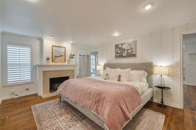 1114 Glenwood Ave, Nichols Hills, OK 73116 - bedroom featuring crown molding, wood finished floors, a decorative wall, a fireplace with flush hearth, and recessed lighting
