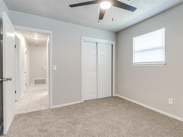 3013 Beverly Dr, Edmond, OK 73013 - unfurnished bedroom featuring light colored carpet, a closet, a ceiling fan, and light tile patterned flooring
